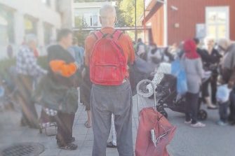 Vartija valvoo vapaaehtoisia ruoanjakajia