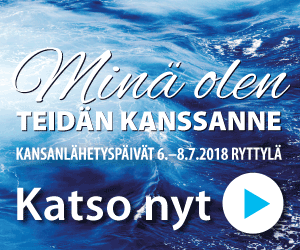 Tumma lettipäinen nainen iltamaisemassa korkealla kukkulalla metsä- ja kaupunkimaisemaa vasten.