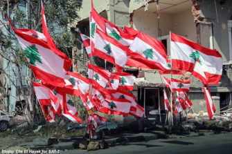 Libanonin liput liehuvat raunioiden keskellä Beirutissa.