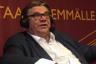 Timo Soini istumassa kuulokkeet korvilla Radio Dein studiossa