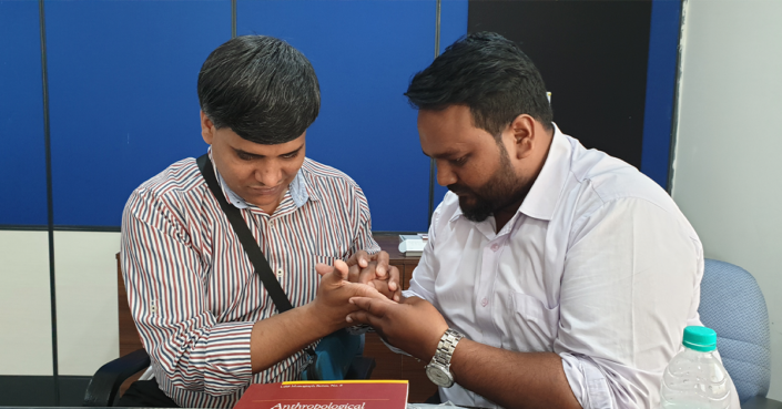 Intialainen pradeep kirjoittaa miehen käteen tervehdystä