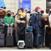 Ihmisiä matkalaukkuineen Lvivin rautatieasemalla, Ukrainassa.