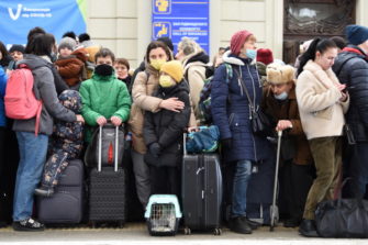 Ihmisiä matkalaukkuineen Lvivin rautatieasemalla, Ukrainassa.