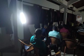 Ihmisiä opiskelemassa Raamattua pimeässä huoneessa sähkökatkon aikana