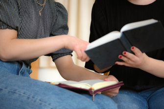Kaksi naista tutkii Raamattua ja toista kirjaa