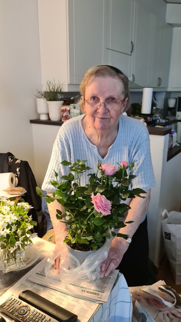 Anja Nurminen kotonaan Espoossa keväällä 2022. Hän asettelee kuvassa kukkia maljakkoon keittiössään.