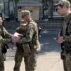 Radio-ohjelman juontaja tapaa sotilaita ja jakaa heille materiaalia.