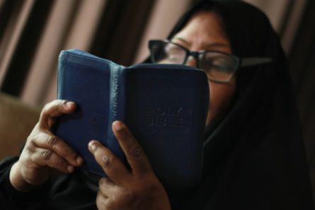 Vainottu kristitty lukee sinikantista Raamattua