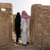 Mustaan huntuun verhottu nainen ja saudimies seisovat kirkon raunioissa.