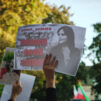 Mielenosoittaja pitää kädessään Masha Aminin kuvaa.