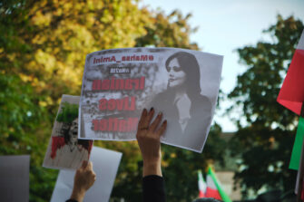 Mielenosoittaja pitää kädessään Masha Aminin kuvaa.