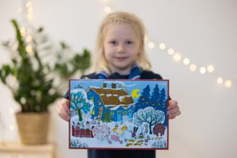 vaaleahiuksinen pikkutyttö pitää kädessään joulukalenteria