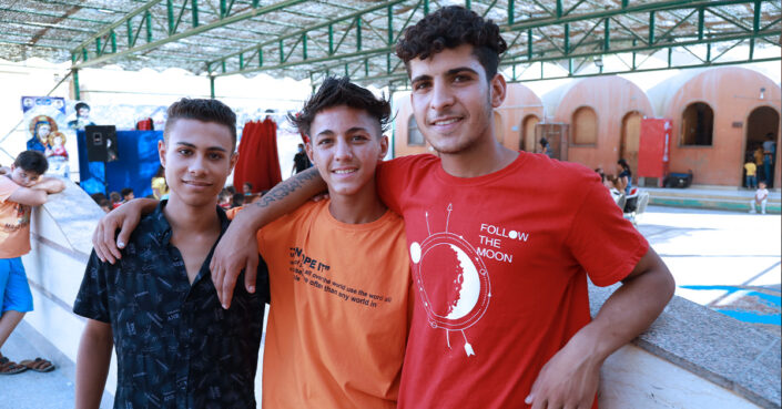 Kolme egyptiläistä nuorta pyhäkoulunopettajaa hymyilee.