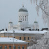 talvinen kuva valkoisesta kirkosta, joka näkyy kuvassa taka-alalla. Edessä muita rakennuksia.