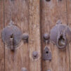 Lähikuva vanhan oven yksityiskohdista. Ovi on kulunut ja siinä on rautaisia yksityiskohtia sekä avaimenreikä.