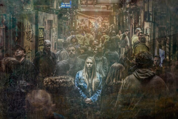 piirroskuvalta näyttävä valokuva väkijoukosta, jonka keskellä vaaleahiuksinen nainen katsoo suoraan eteenpäin