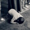 lapsi kumartuneena rukoukseen mustavalkokuva