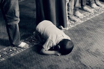 lapsi kumartuneena rukoukseen mustavalkokuva