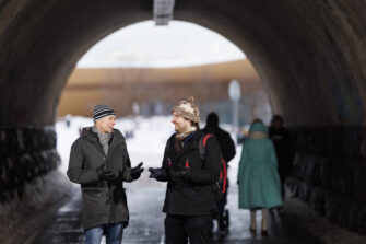 Kaksi miestä pipot päässä tunnelissa.