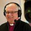 Piispa Bo-Göran Åstrand kuulokkeet korvilla radiostudiossa.