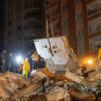Ihmisiä maanjäristyksessä romahtaneen talon raunioilla Turkissa.