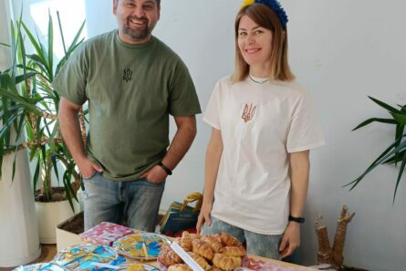 Katetun kahvipöydän äärellä seisoo ukrainalaispariskunta. Ukrainalaiset Stanislav ja Julia Bekher auttoivat talkoolaisina Pieksämäen lähetystorilla ja kahvilassa. Kuva: Sari Sormunen