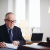 Presidentti Martti Ahtisaari käymässä kirjeenvaihtoa kirjoituspöytänsä takana.
