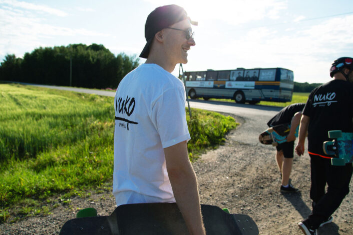 nuori mies pitelee skeittilautaa hymyillen