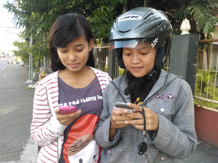 Indonesialaiset tytöt kännykät kädessä.