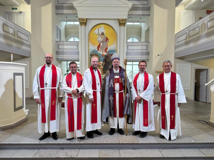 Viisi vihittyä pappia poseeraavat rivissä Inkerin kirkon piispan vieressä.