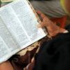 Nainen pitää käsissään Raamattua.