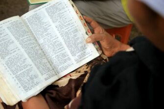 Nainen pitää käsissään Raamattua.