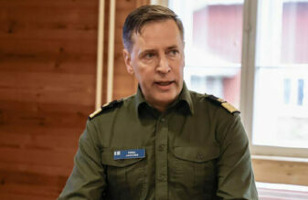 Pekka asikainen istumassa sotilaspuku päällä.