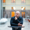 Olli-Pekka Vainio seisoo korkean pöydän ääressä.