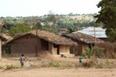 Savesta tehtyjä taloja, joiden edustalla muutama tummaihoinen lapsi. Taustalla afrikkalaista luontoa.