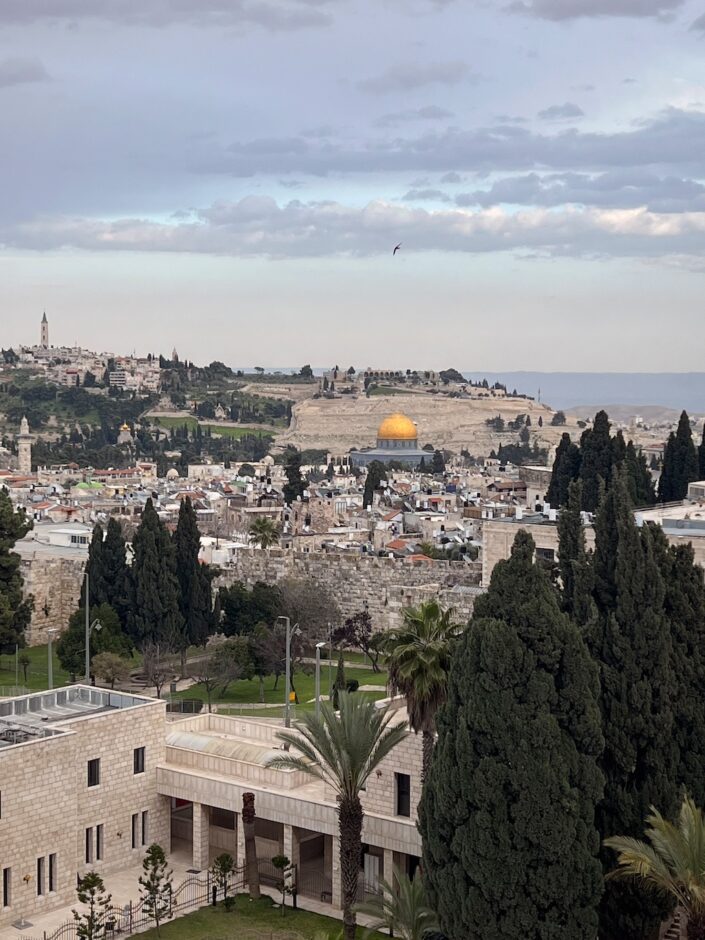 Jerusalemin kaupungin siluetti. Keskellä sinertävä moskeija jolla on kultainen katto.