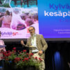 Mies ja nainen keskustelevat esiintymislavalla. Taustalla näkyy mainosdia, jossa lukee Kylväjän kesäpäivät.