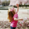 a_girl_standing_under_tree_holding_a_teddybear_photo_unsplash