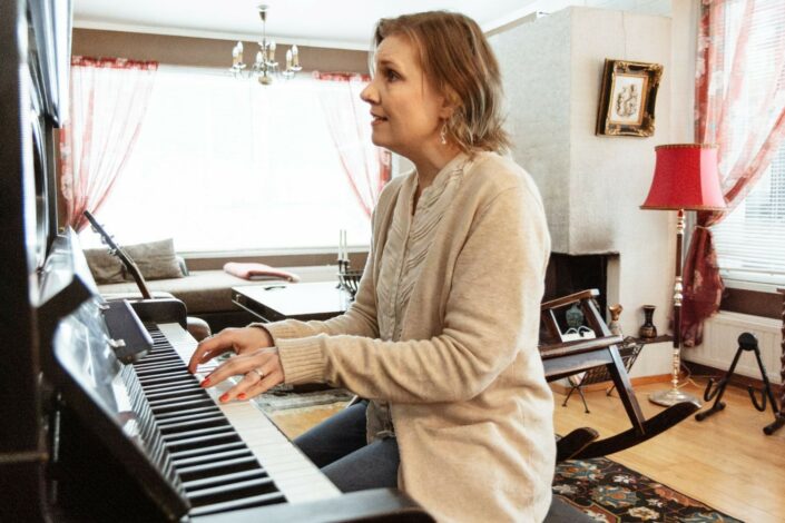 Elina Uusikylä soittaa pianoa ja laulaa.