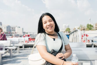 Nuori thaimaalaisnainen Manatip Wongkhuan hymyilee lautan kannella.
