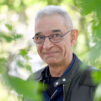 a_man_smiling_and_looking_at_camera_leaves_trees_photo_Saija_Tiilikainen