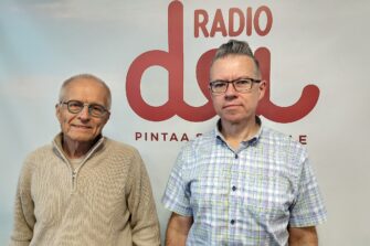 Eero Junkkaala ja Juha Ahvio Radio Dein studiossa Dei-logon edessä.