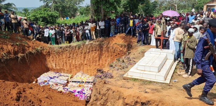 Avoinna oleva joukkohauta, ympärillä paljon afrikkalaisia ihmisiä.