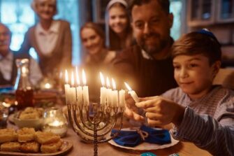 Poika sytyttää kynttelikköä.