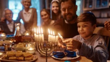 Poika sytyttää kynttelikköä.