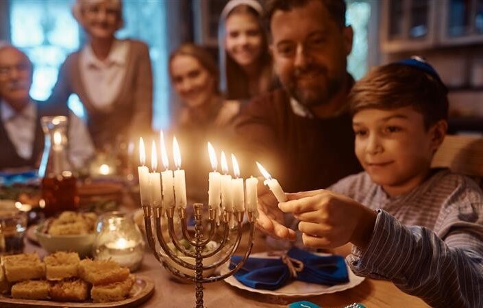 Poika sytyttää kynttelikköä.