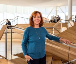 nainen rappusissa seisoo ja katsoo kameraan