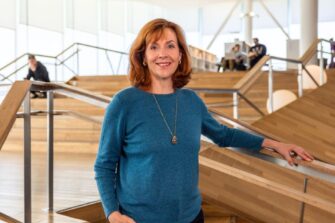 nainen rappusissa seisoo ja katsoo kameraan