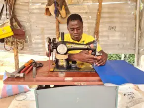 Mies ompelukoneen ääressä.