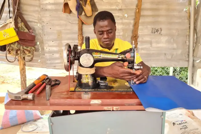 Mies ompelukoneen ääressä.